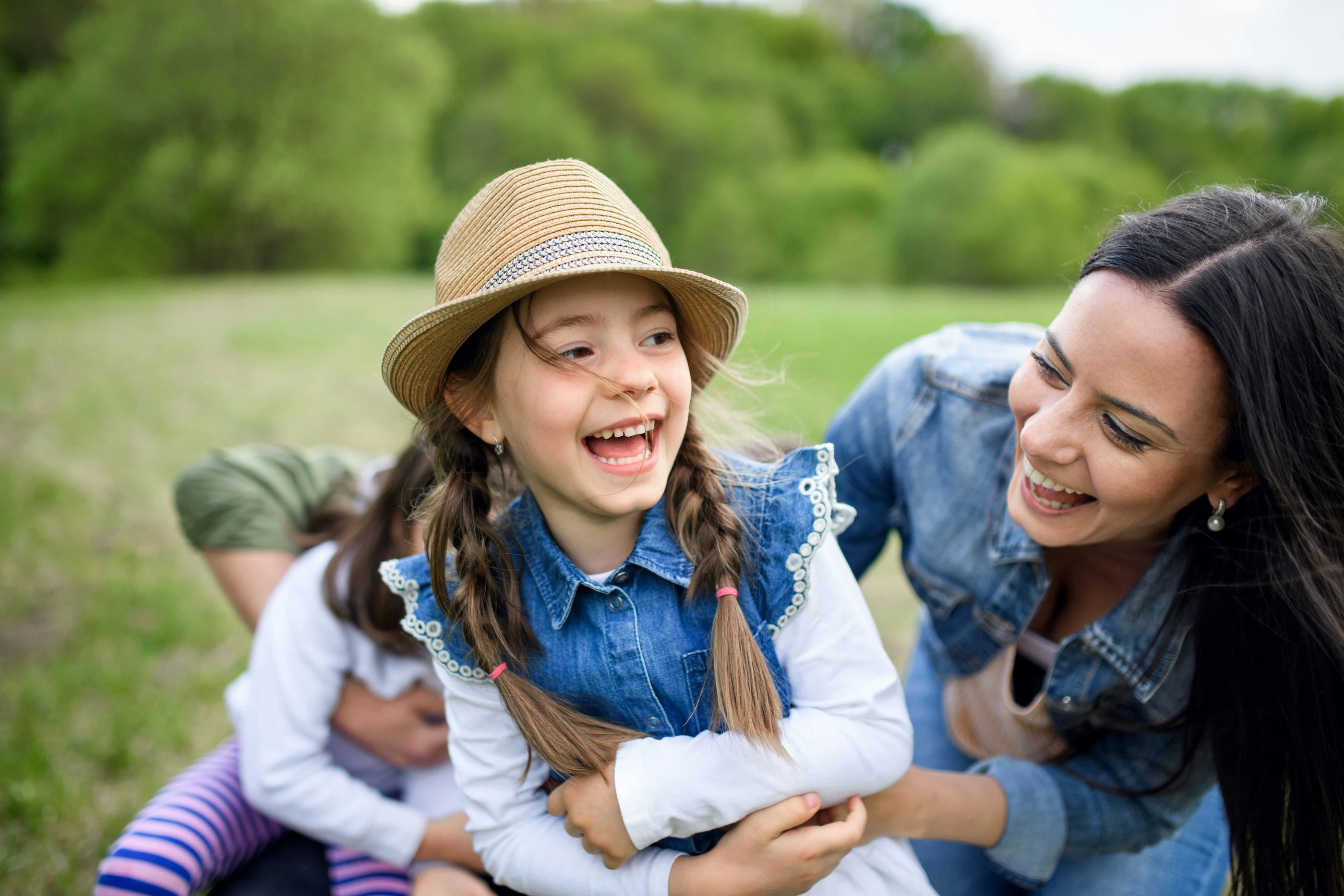 A mother and her daughter sharing a happy moment outdoors.